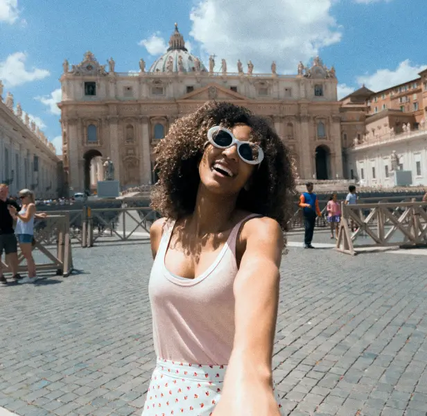 Woman on holiday in European city, holding the hand of the person taking the phot