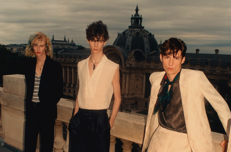 Three men on an outdoor patio wearing designer YSL clothing