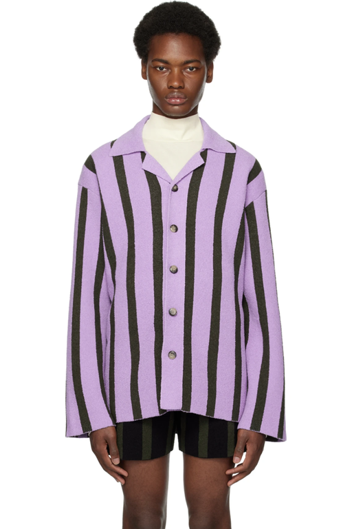 A man wearing a striped lavender button up with a cream turtle neck by Nanushka 