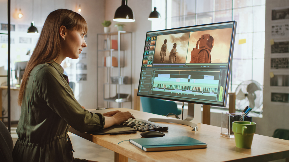 Female Video Editor Works with Footage on Her Personal Computer with Big Display.