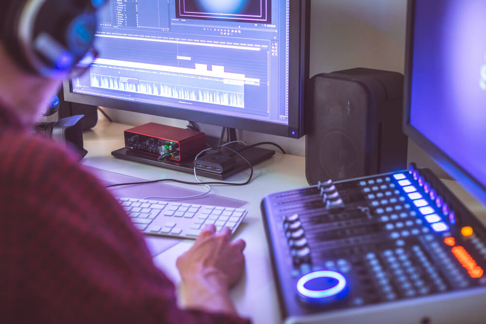 Sound designer in studio creating sounds for film with monitors