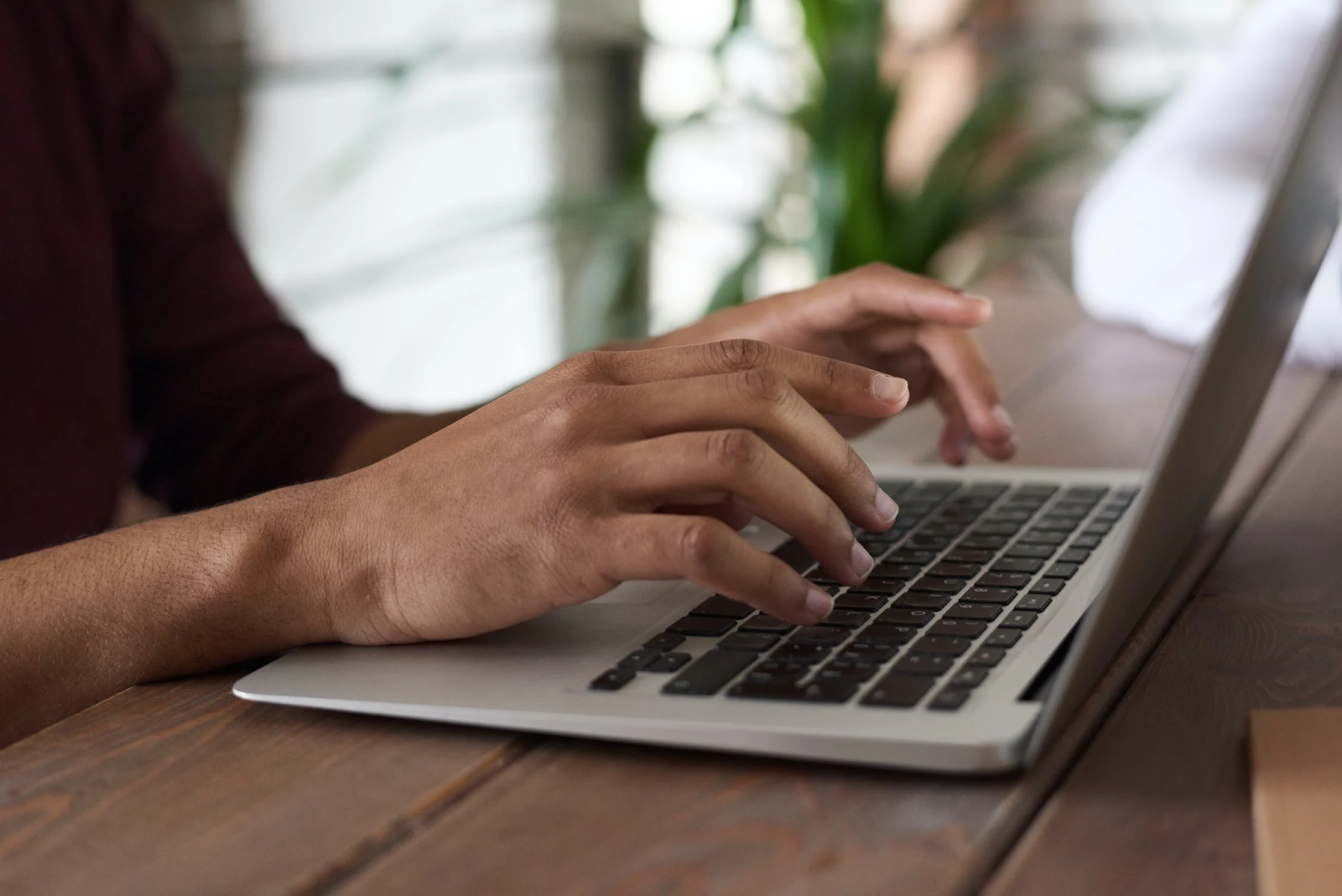 A photo of a person typing on a laptop keyboard