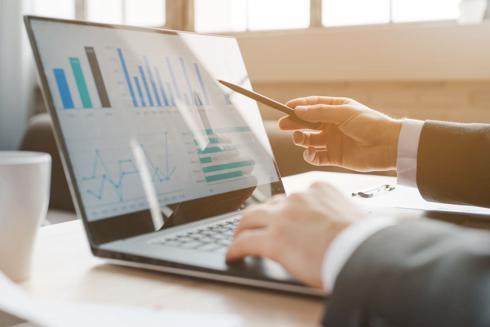 A close-up photo of a businessman analyzing financial data on a laptop 