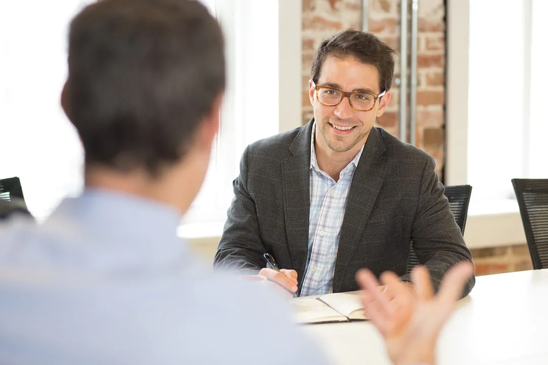 a man in a suit talking to another man