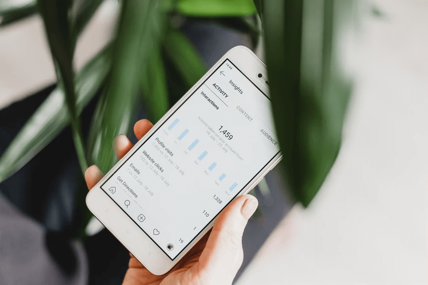 A person holding a smartphone showing Instagram Insights