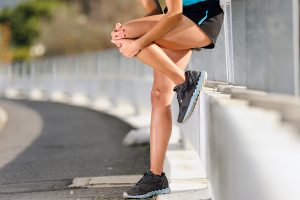 knee injury for athlete runner. woman in pain after hurting her leg while training for fitness marathon