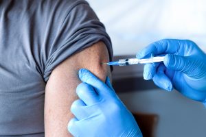 A man gets a vaccine in his left arm.