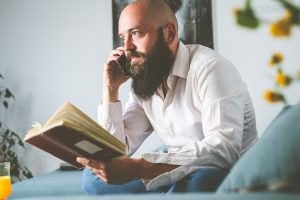 Man holding a book and talking on the phone