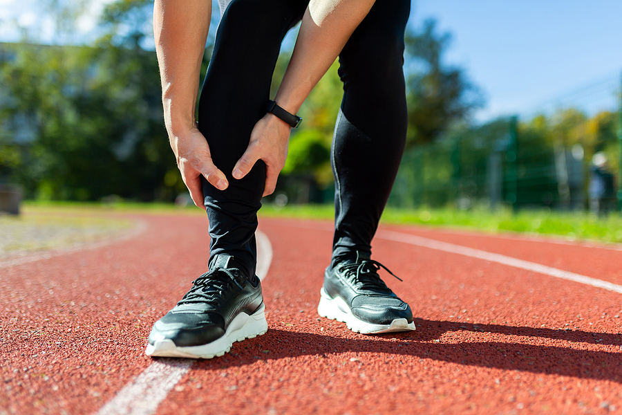 A runner grabs their calf after suffering a sports injury
