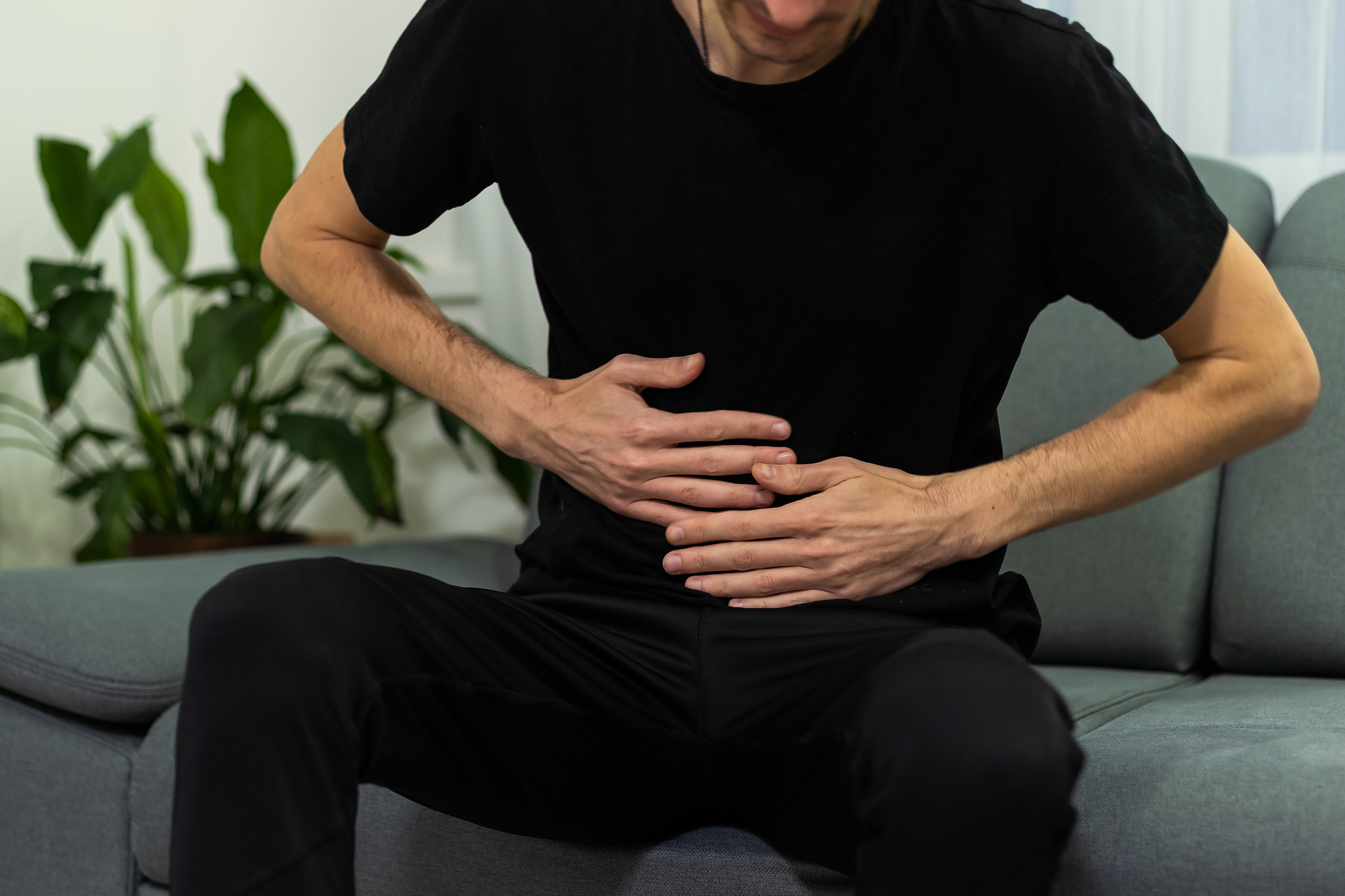 Man doubles over in pain from a stomachache.