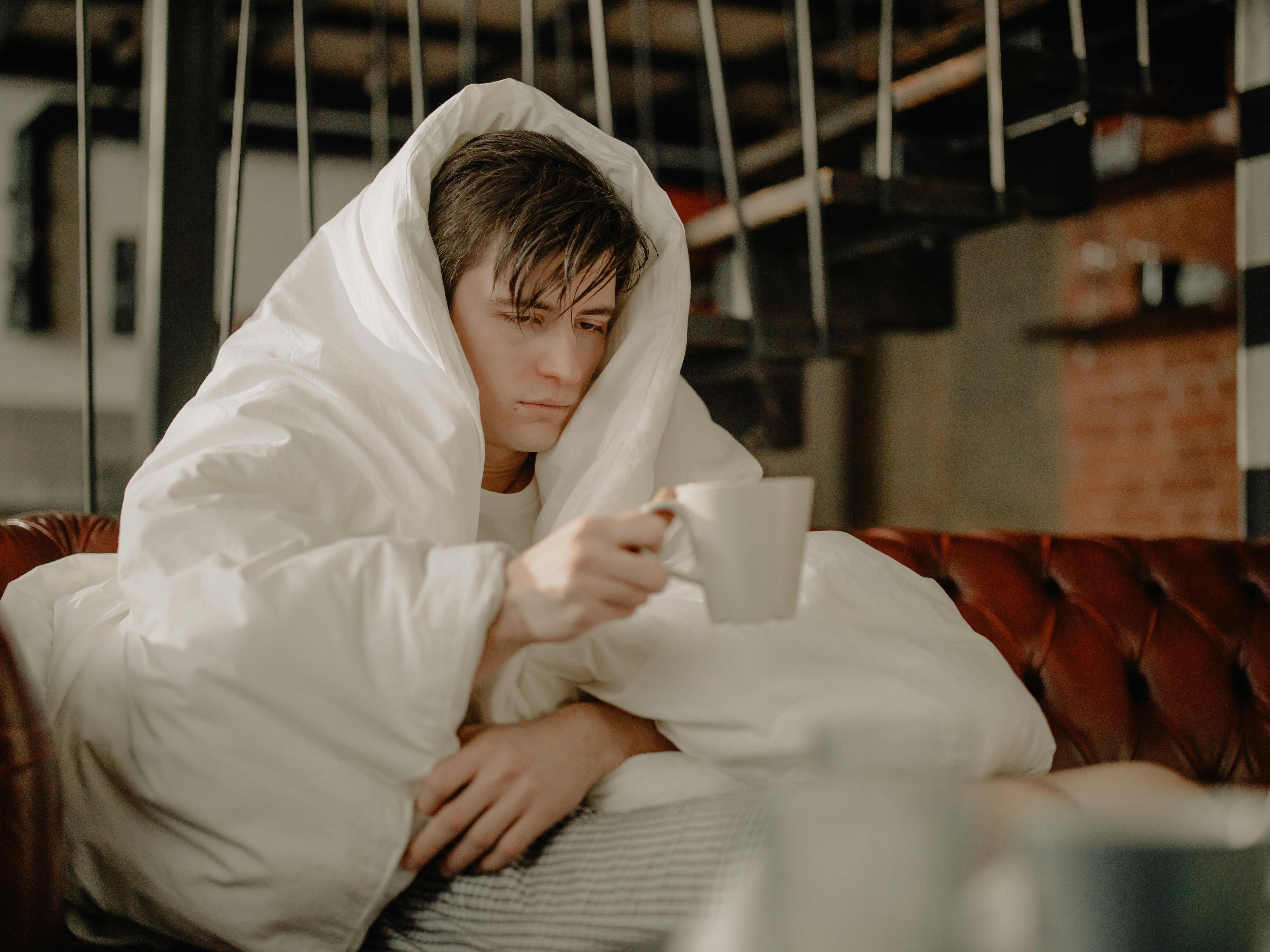 Picture of a sick man covered in blankets