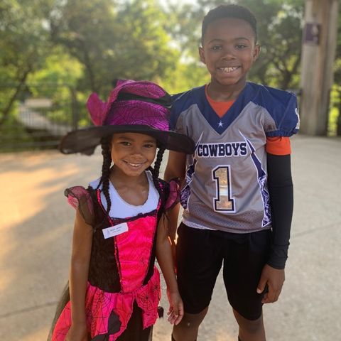 Two smiling kids wearing costumes