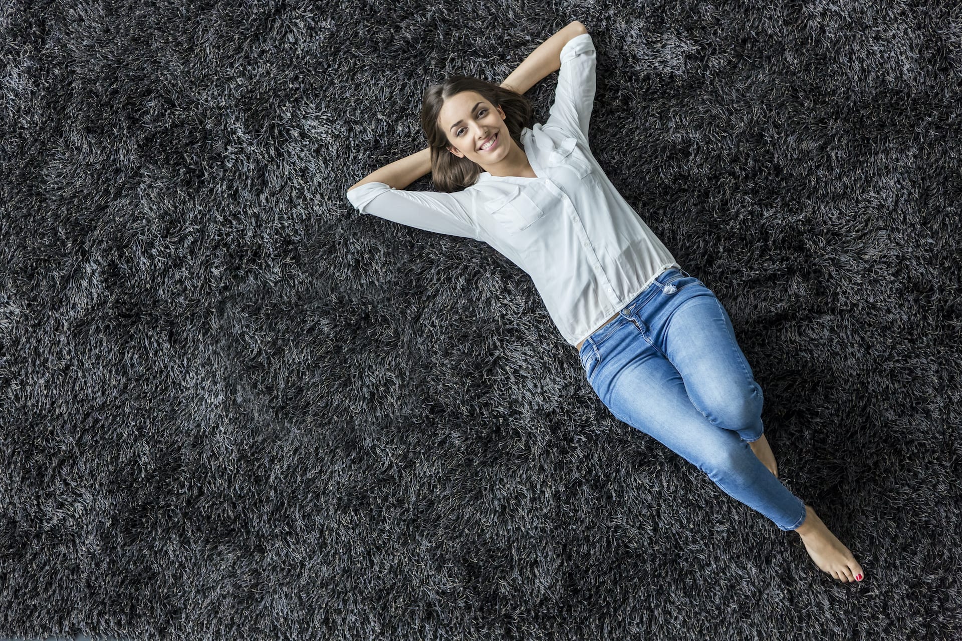 Joyful woman enjoying their newly installed carpet.