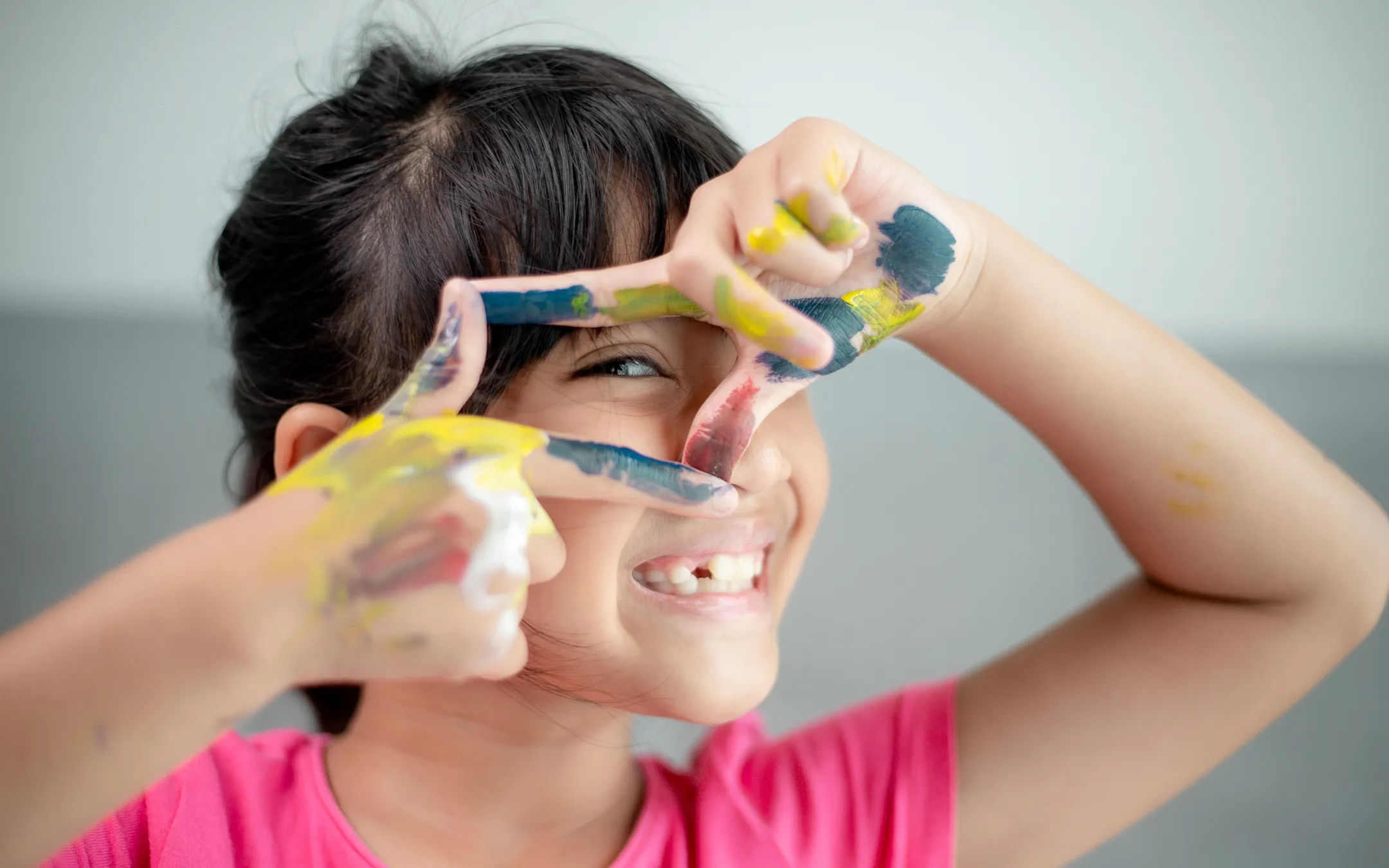 Ein lächelndes Kind mit bemalten Händen