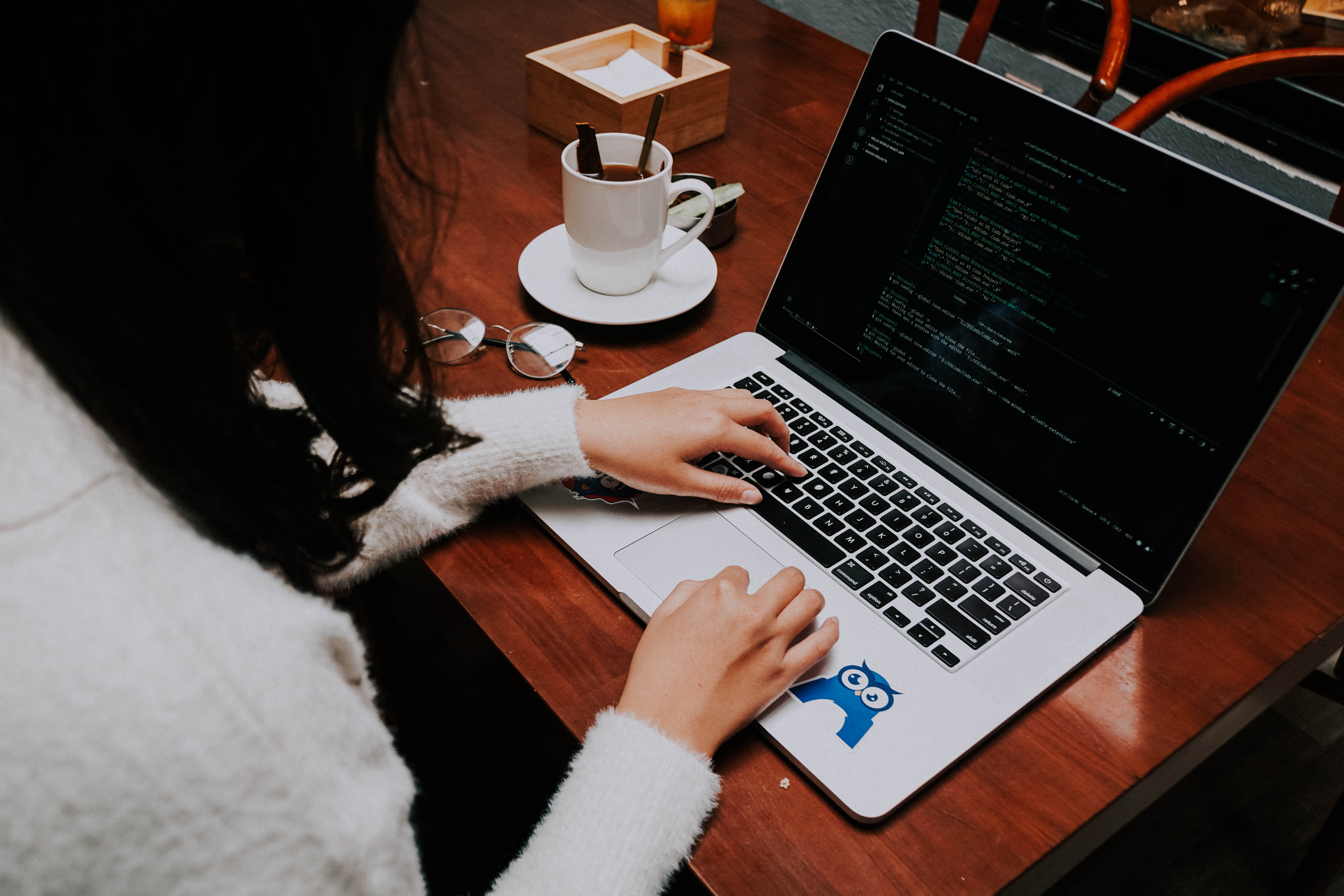 woman coding in a coffee shop - deploy to production