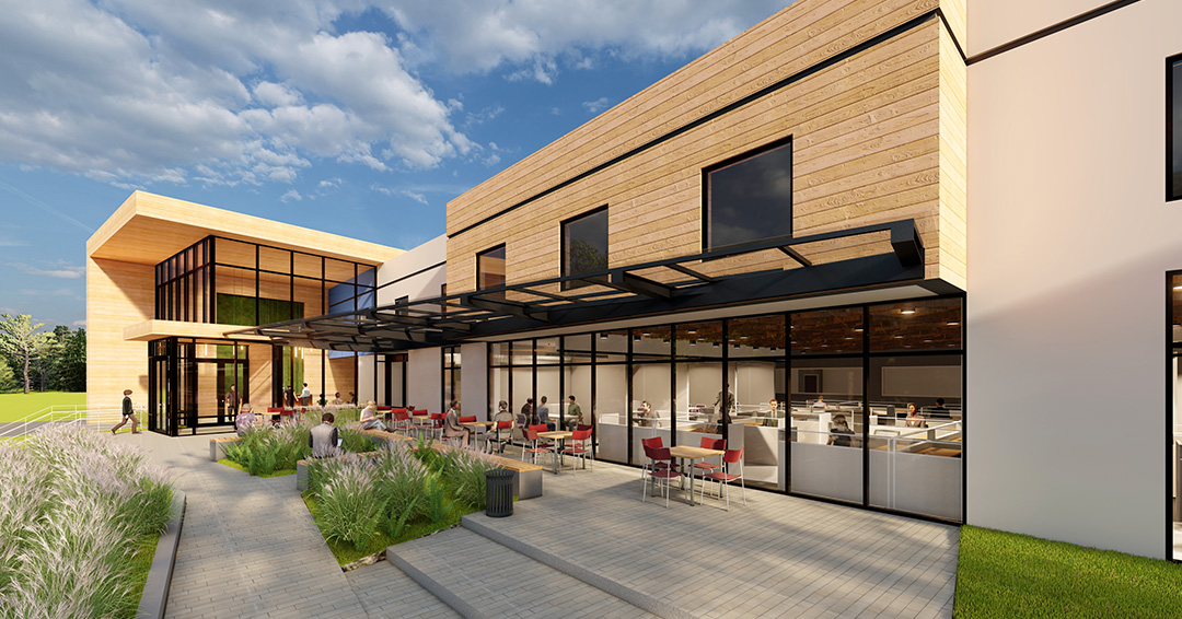 View from front sidewalk into modern office space through glass facade.