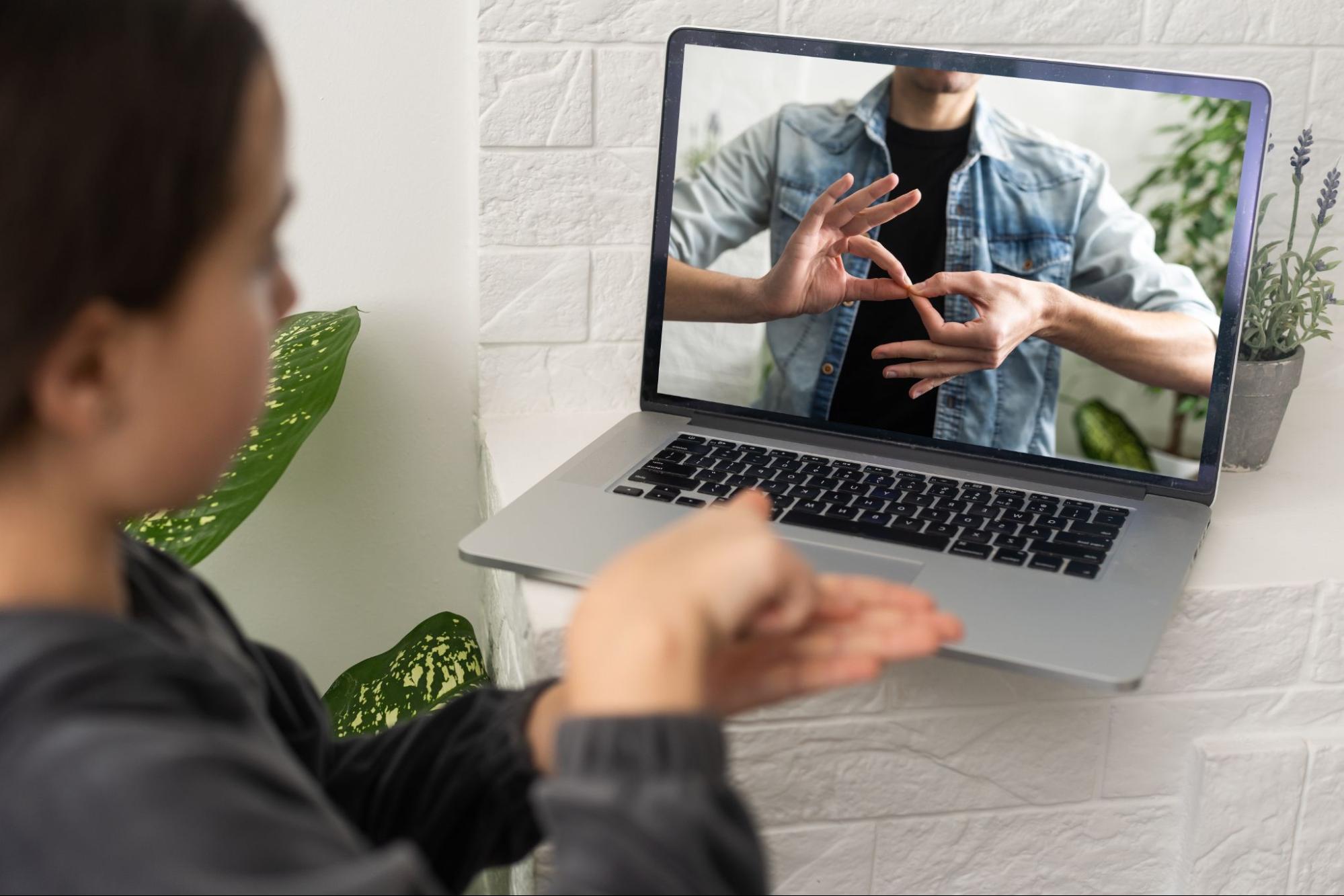 Image of a woman signing to an interpreter on a laptop screen. 