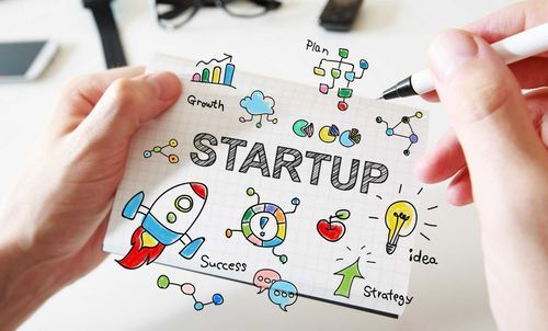 Notebook with doodles around the word startup