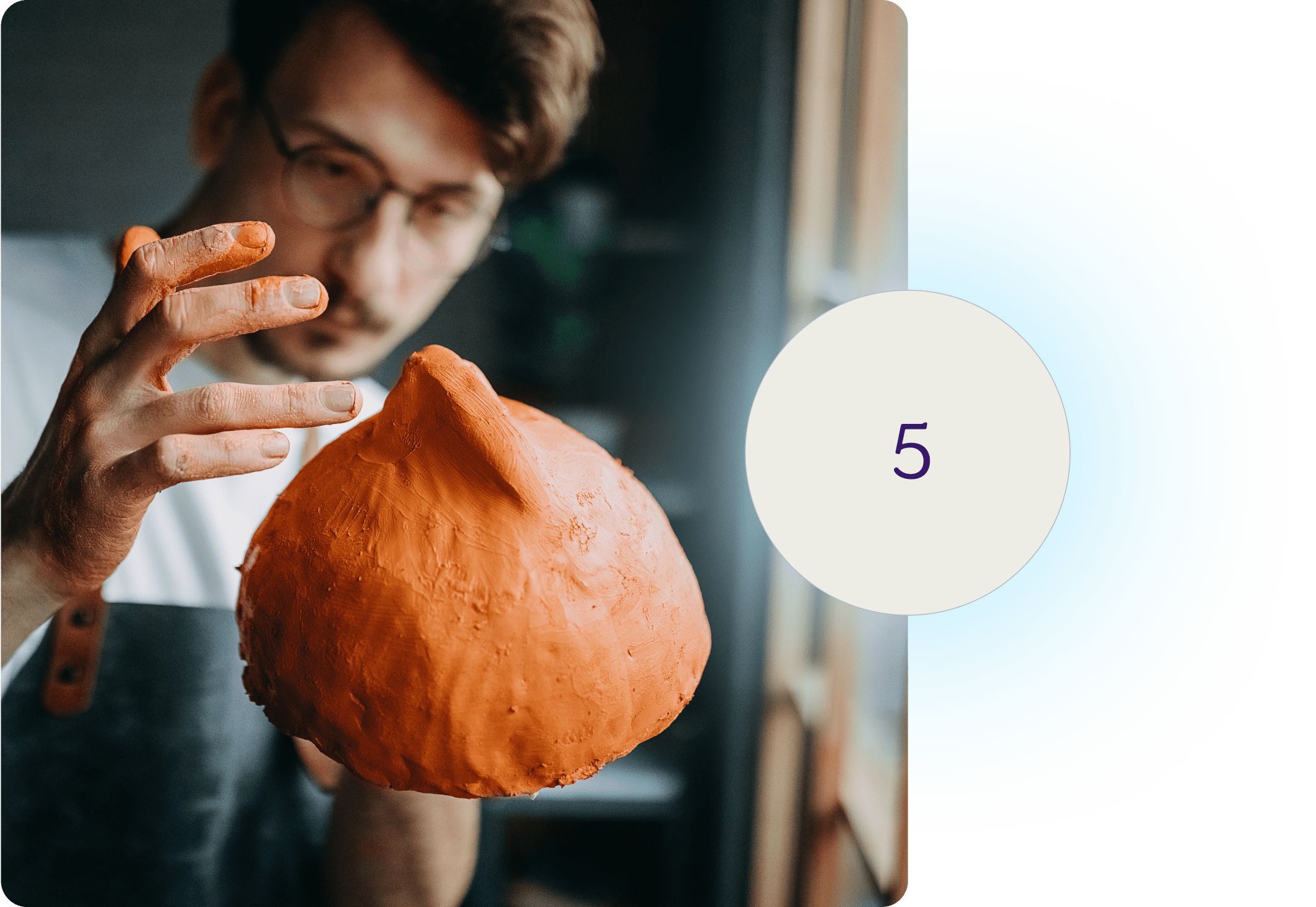 A man working with a piece of clay artwork.