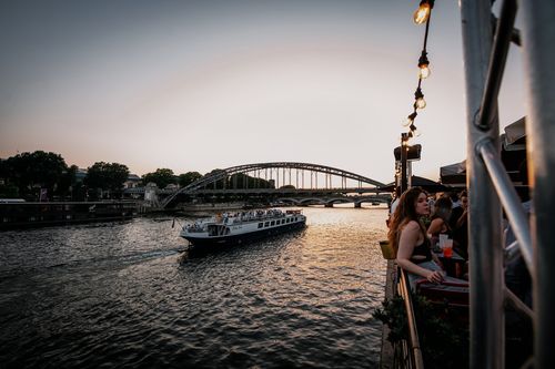 waterfront picture of a boat passing by and people celebrating
