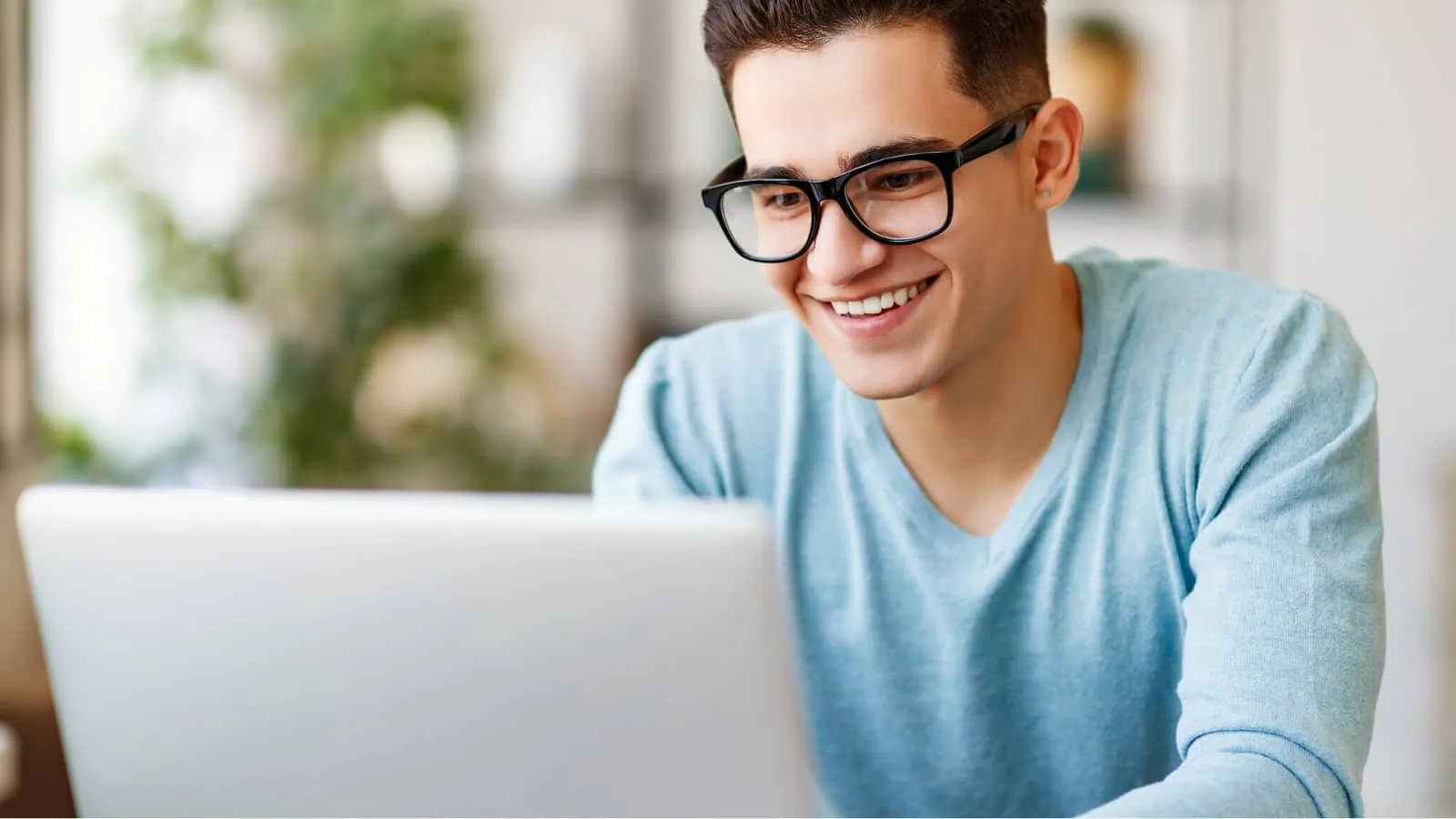 A teenage boy taking the SSAT at Home on his laptop.