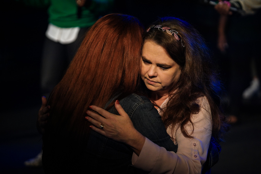 A woman praying with another woman at Motivation Church