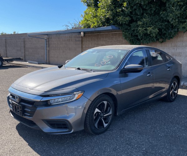 A grey Honda Insight in an empty parking lot