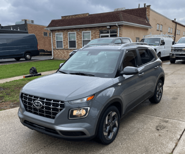 A grey used Hyundai Venue in a crowded parking lot