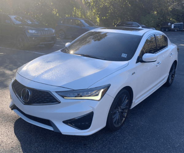 A white used Acura ILX in a parking lot 