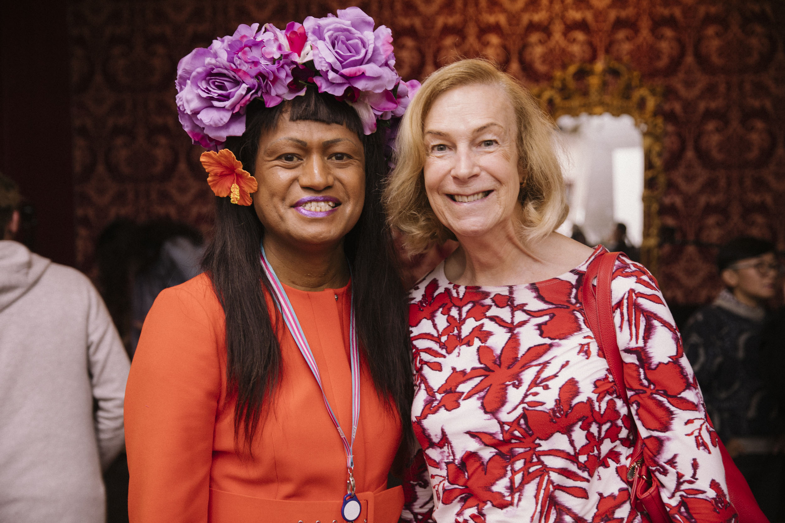 Two trans women standing next to each other and smiling at the camera.