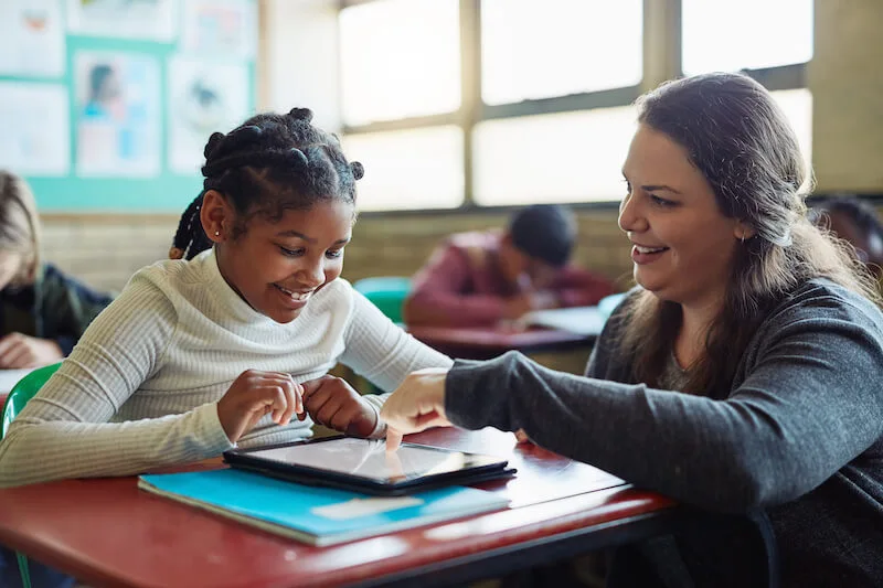 Teacher helping a student using an iPad