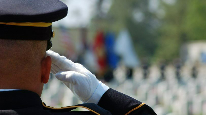 Military Personnel Saluting Flags