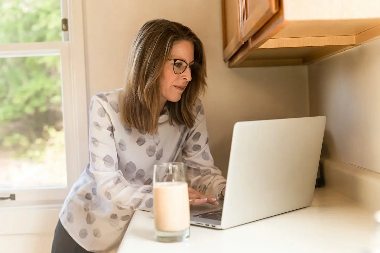 woman-using-gray-laptop-computer-in-kitchen