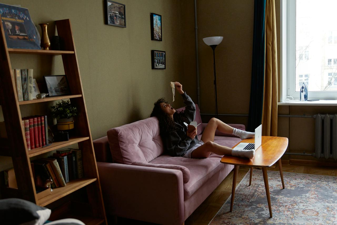 lonely-woman-eating-noodles-on-sofa