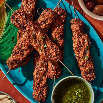 tasty seasoned cultivated meat skewers with a green dipping sauce