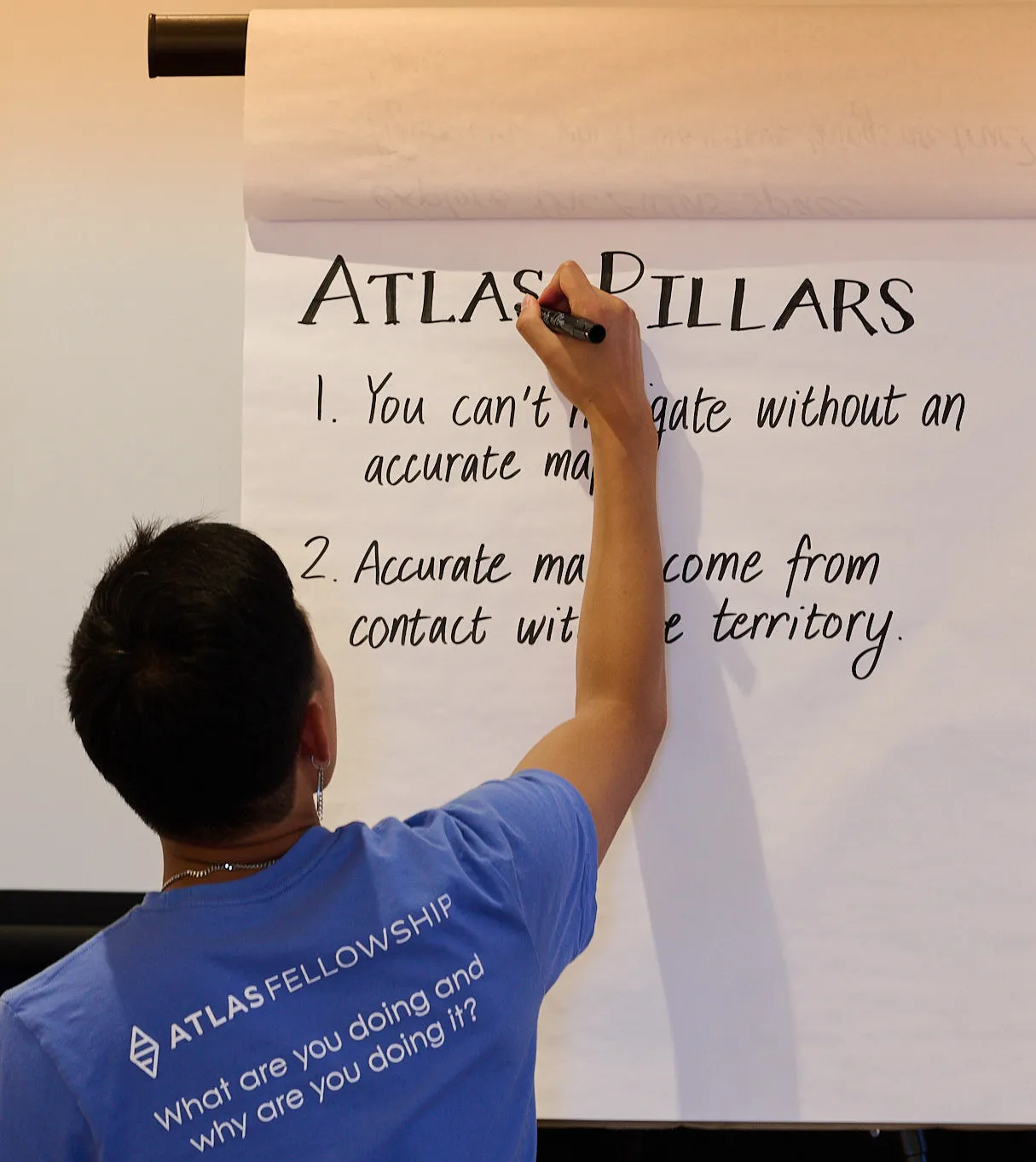 Teacher writing up Atlas Fellowship Pillars