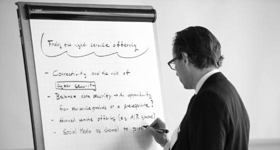 An executive is writing on a whiteboard.