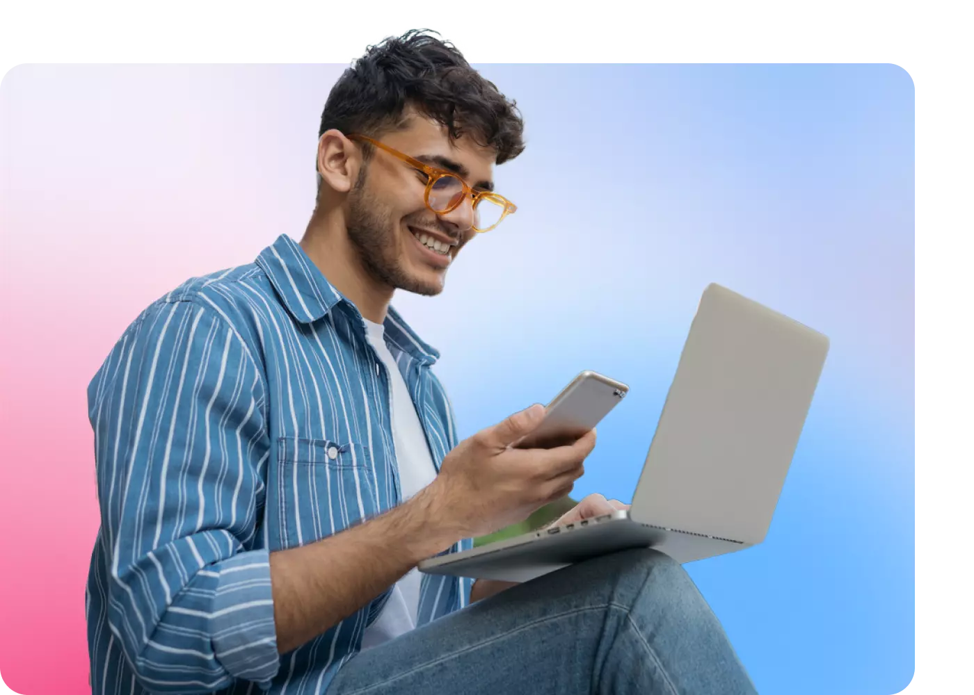 Young man working on a laptop and phone