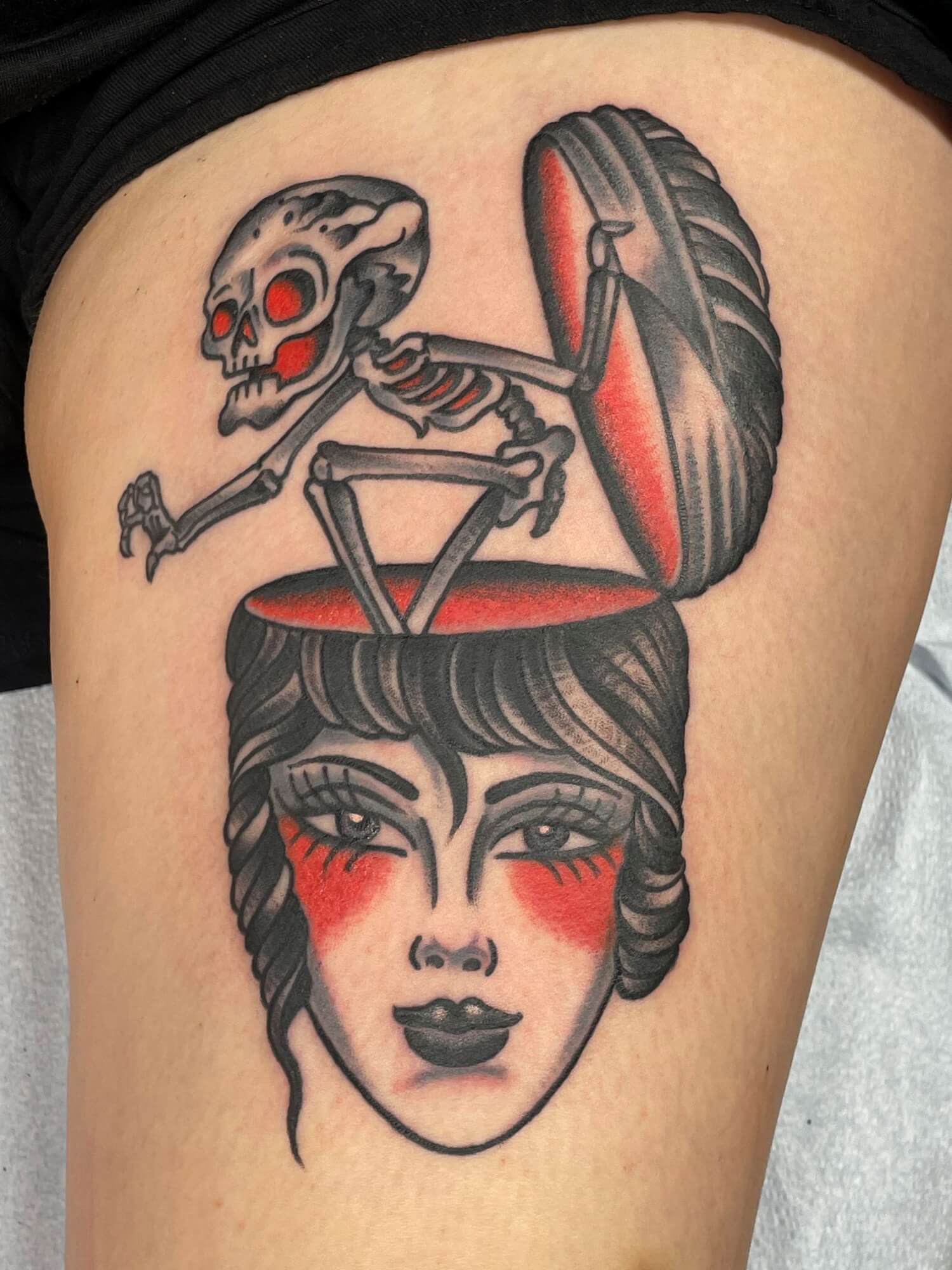 Traditional style tattoo displaying a skeleton exiting the top of a woman's head. Done by Adrian Evans at Saints and Sinners Tattoo