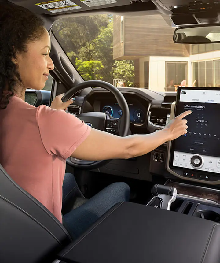 Woman in a car using a dashboard touchscreen