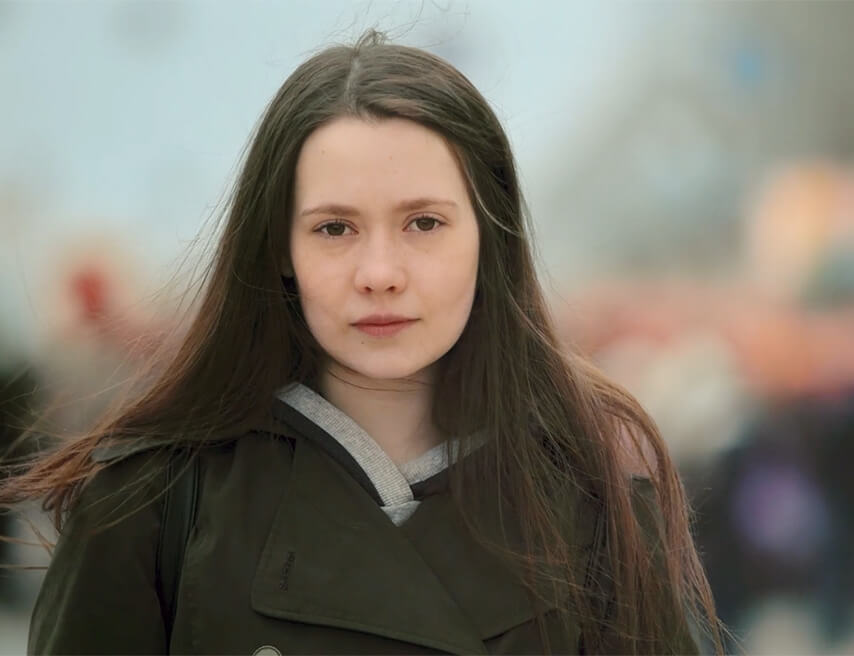 Sad teenage girl in front of blurred out crowd