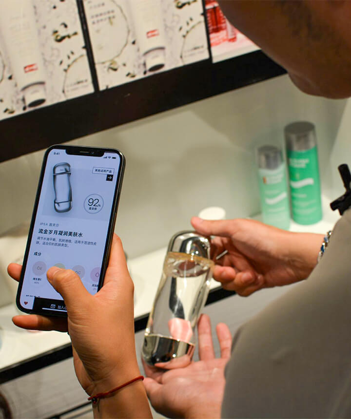 A person scans a perfume bottle with their phone in this cashless Sephora store