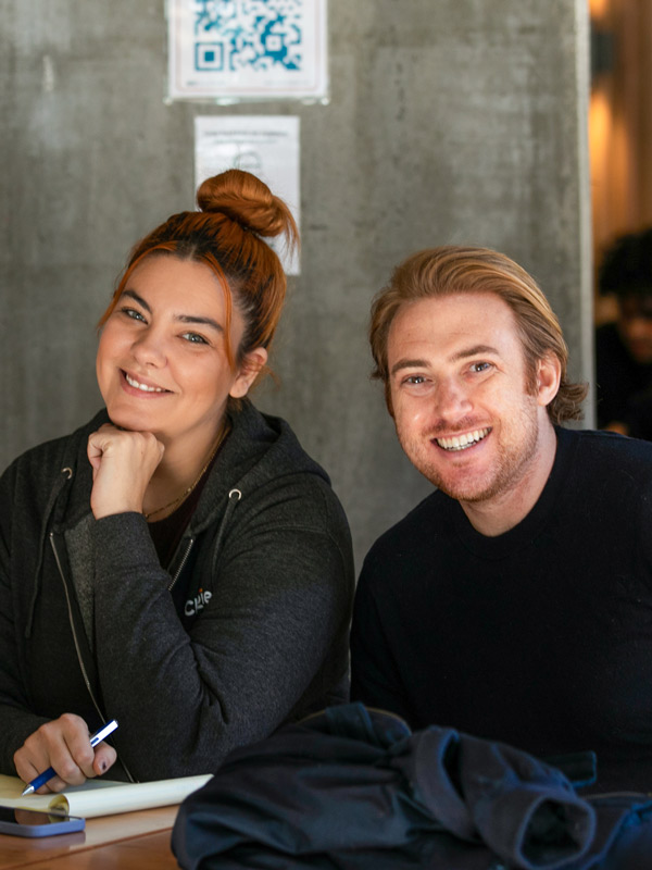 Smiling Chargie team members sit together while preparing for a presentation.