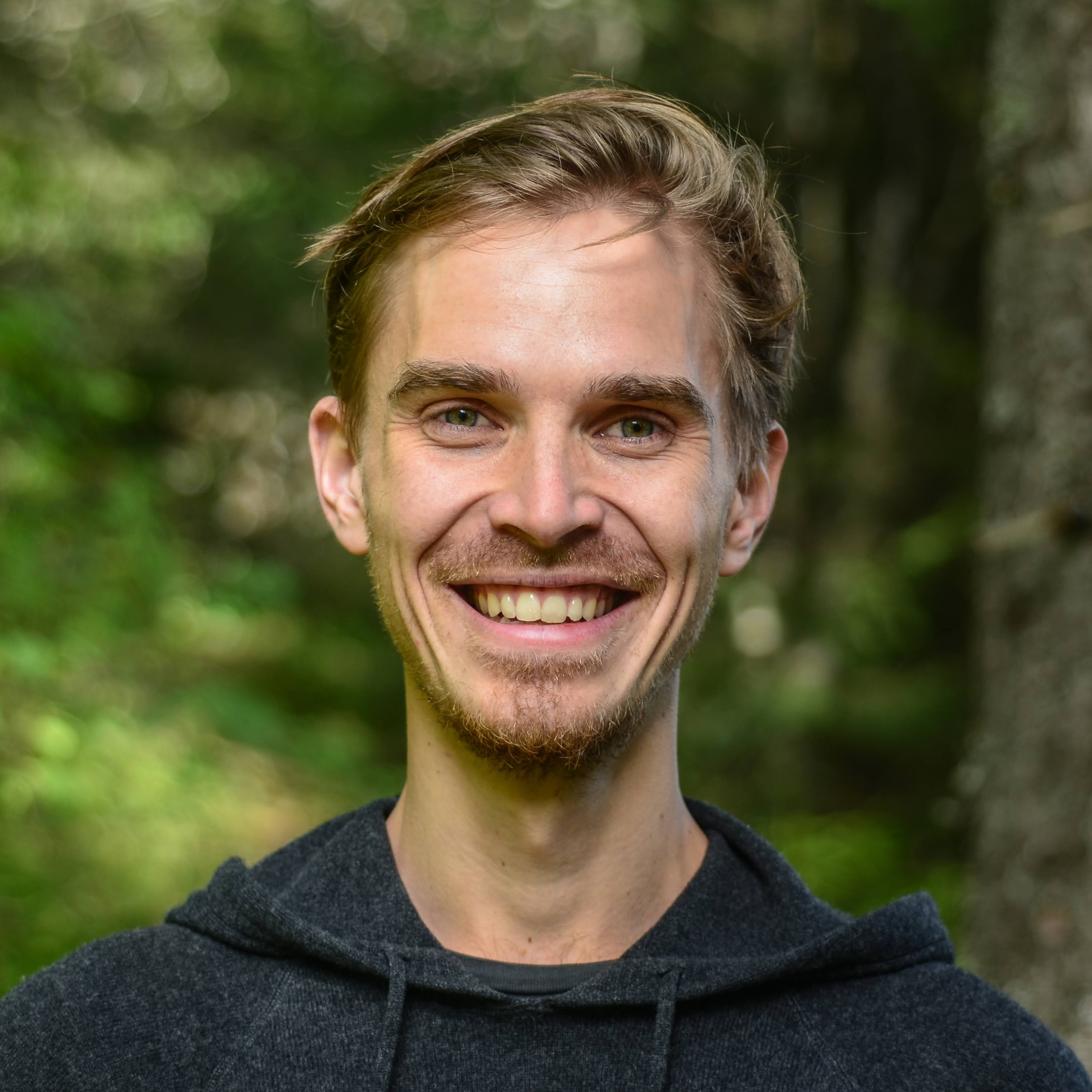 A shot of a man with a blurred forest background