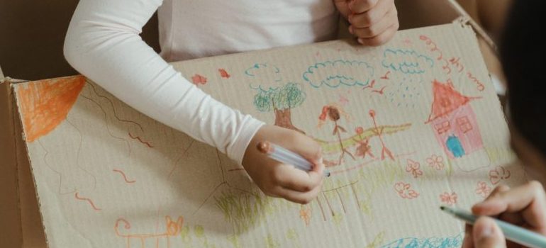 kid painting the moving box