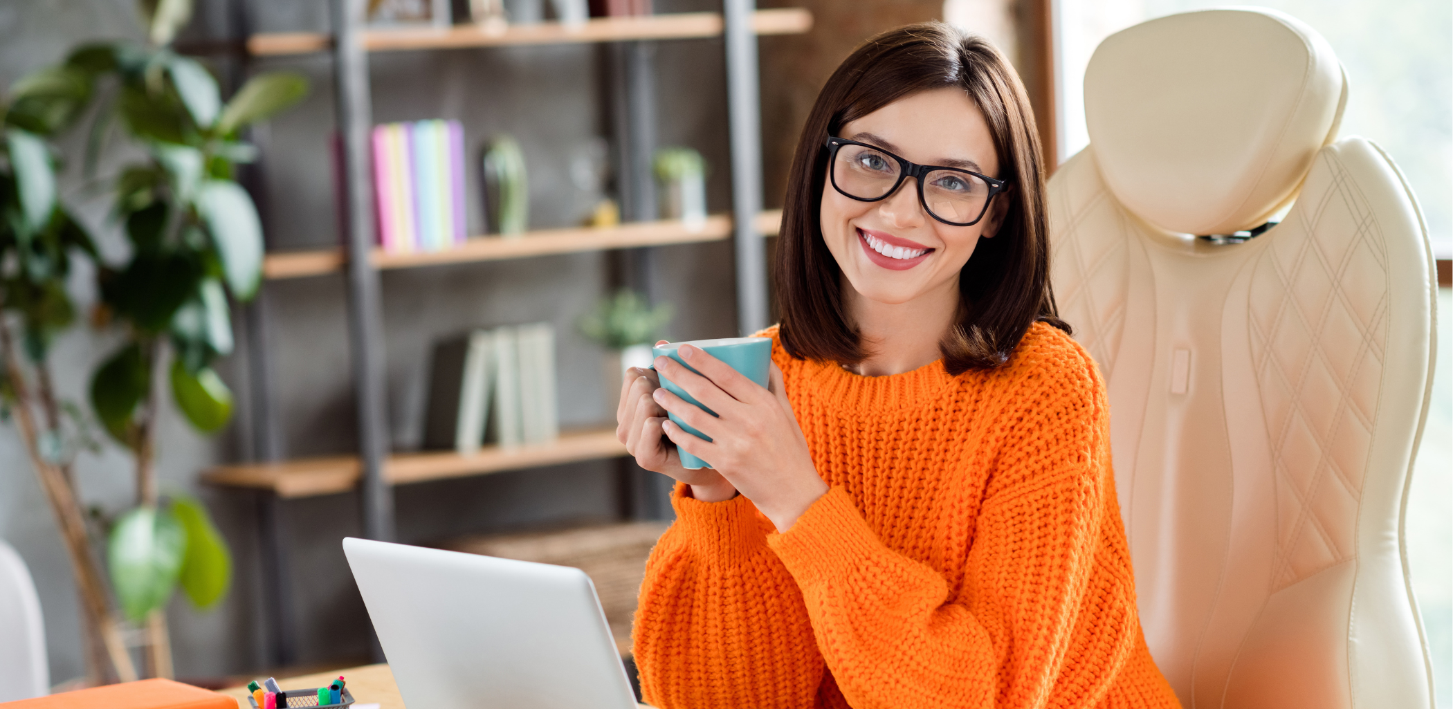 A girl holding a cup of coffee and smiling.