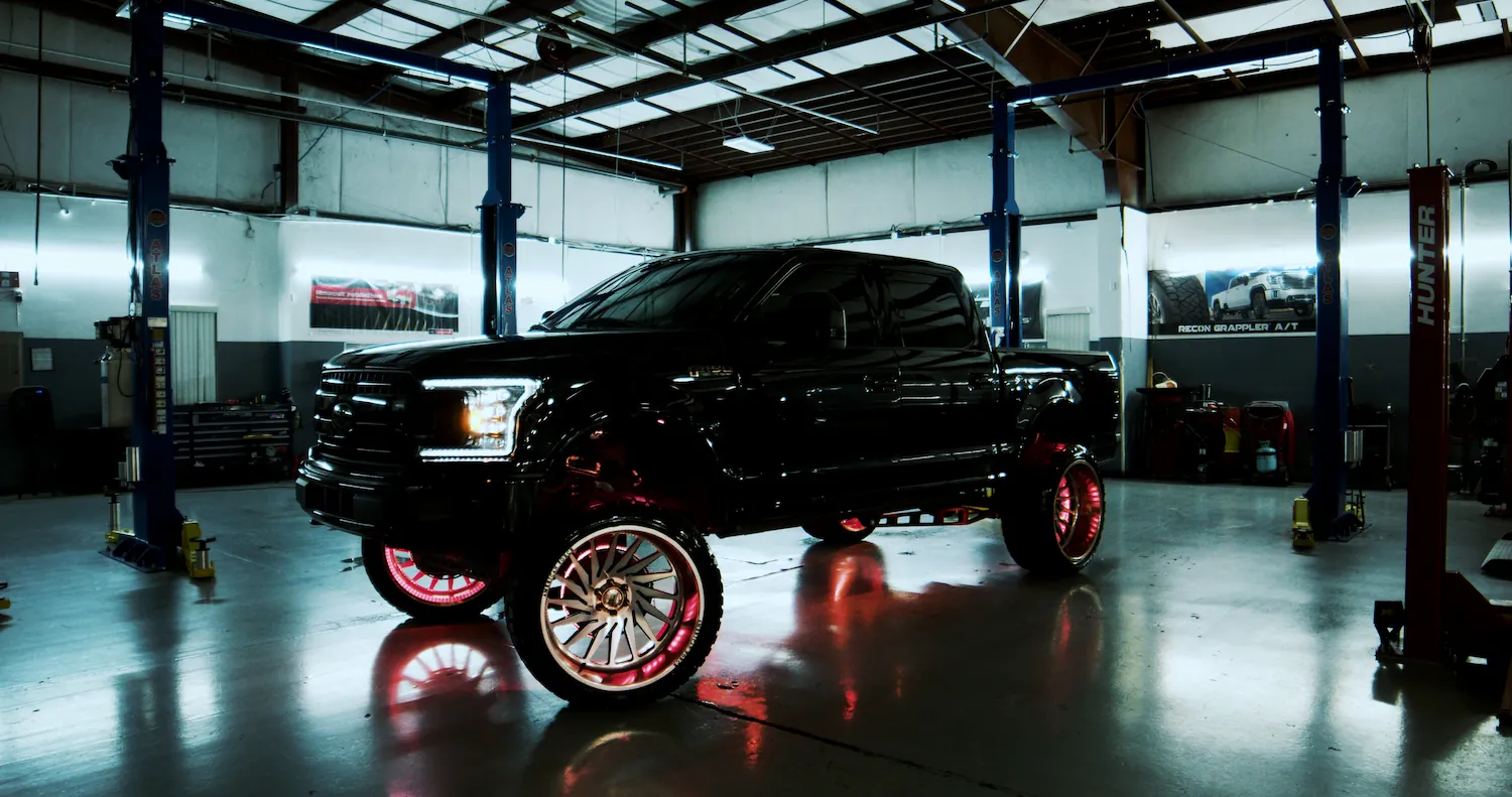 black truck with awesome wheels displayed at the bigg boy auto and marine shop