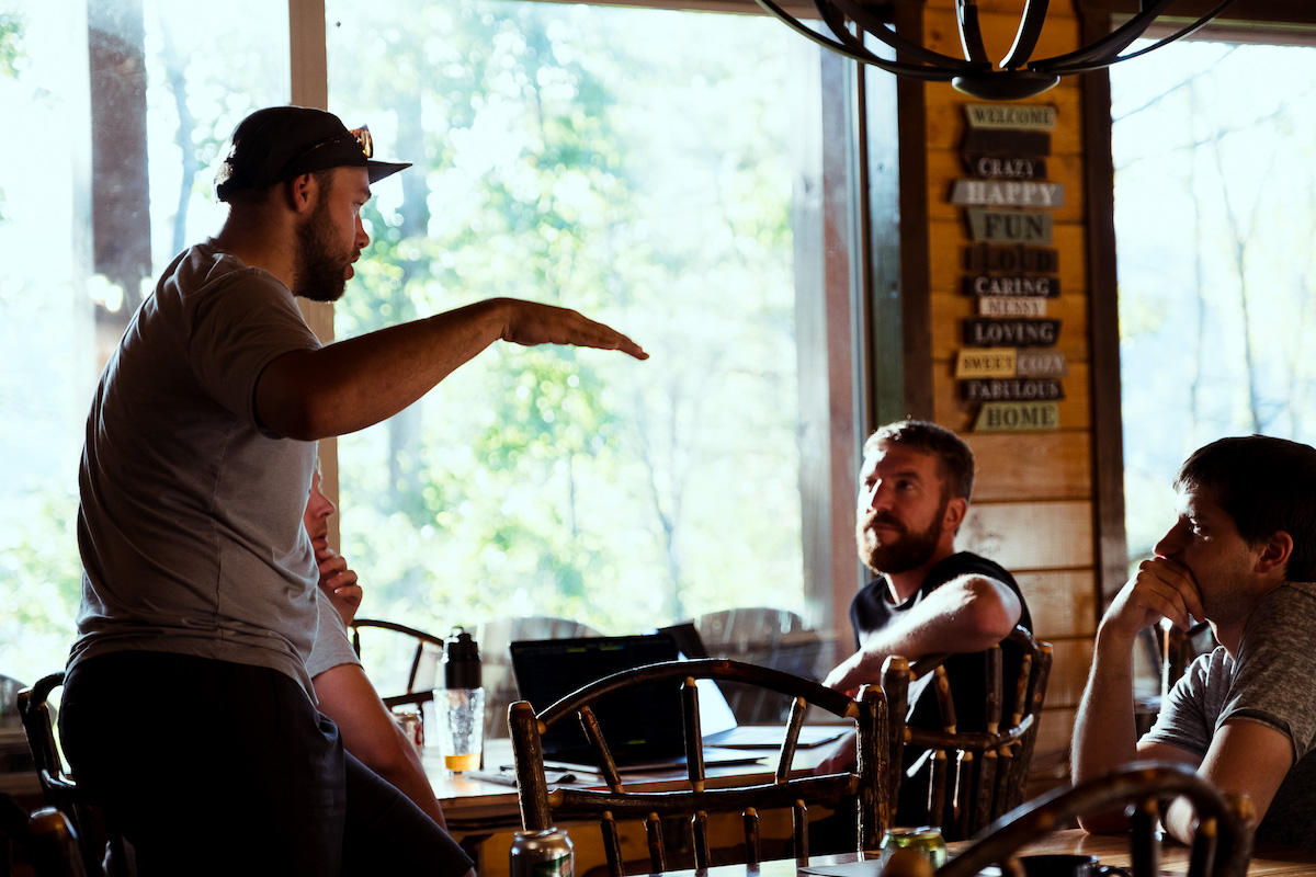 developer leaning on chair and talking to team
