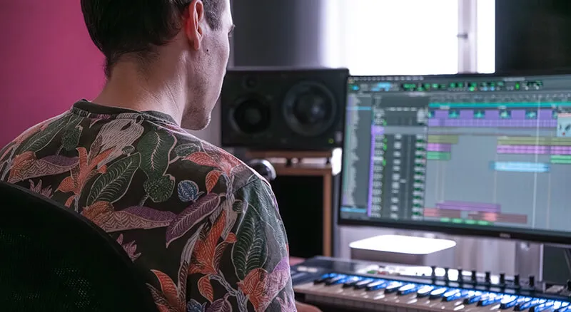 a person sitting in front of a sound workstation