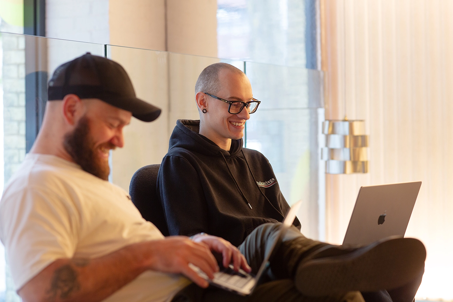 Our Head of New Business & Projects, Dustin, on his laptop smiling next to our CTO, Alan. 